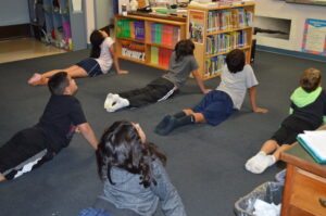 Children practicing yoga cobra pose