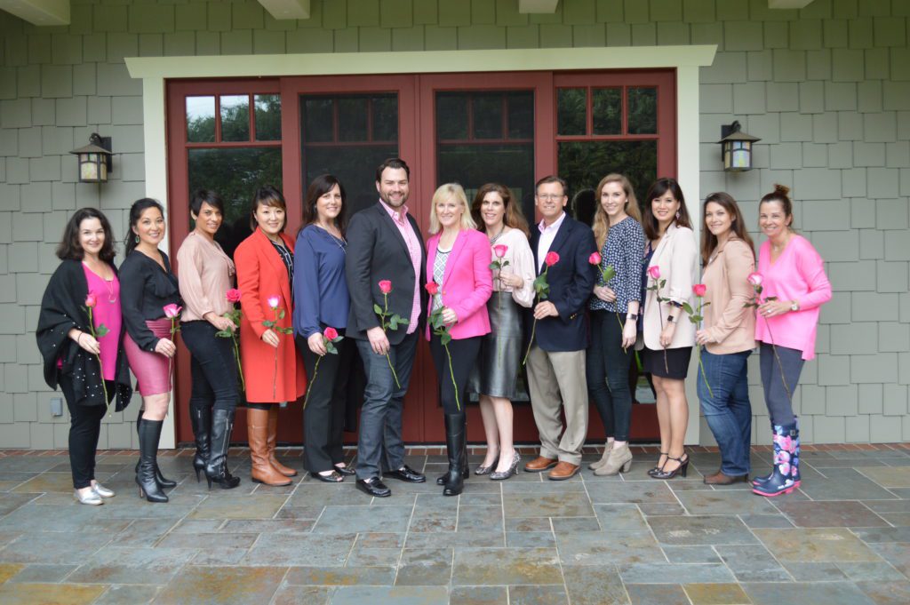 Team standing together with flowers