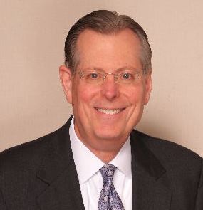 Smiling man in a suit and tie.