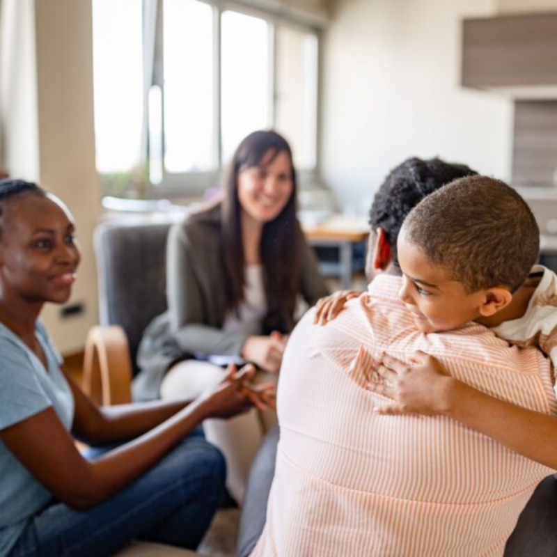 Group therapy session with supportive hug