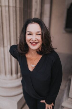 Smiling woman in black outfit outdoors