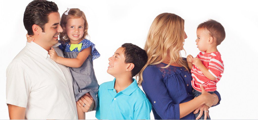 Family of four posing joyfully in studio